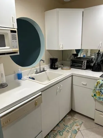a kitchen with a refrigerator and white cabinets