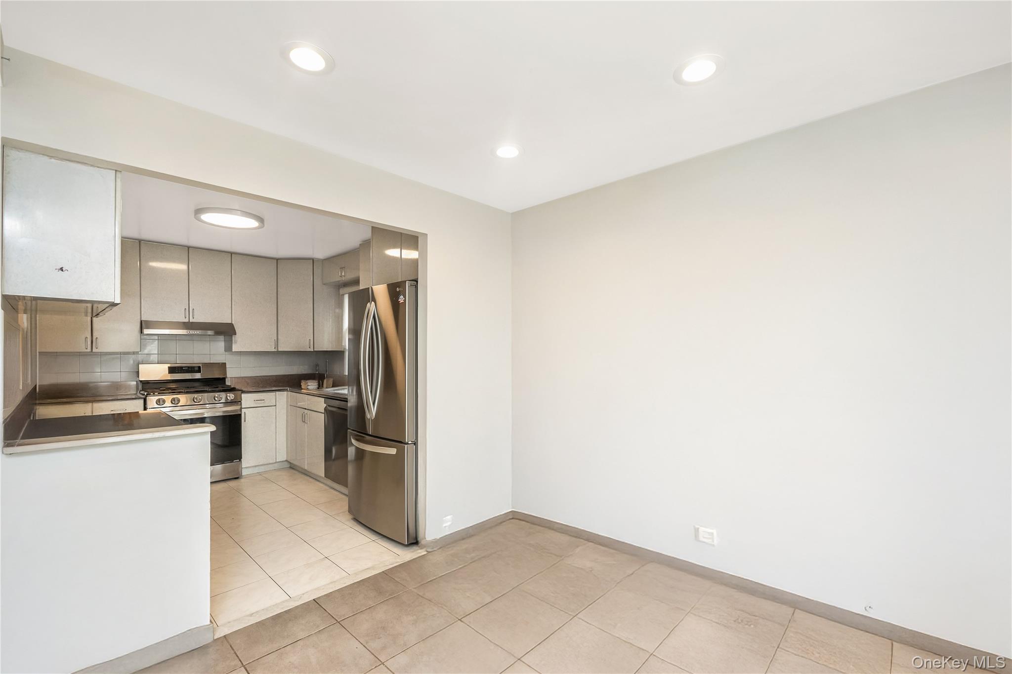 71-59 58th Road Queens, NY 11378 - Photo 13 of 34 a kitchen with stainless steel appliances granite countertop a refrigerator and a stove top oven