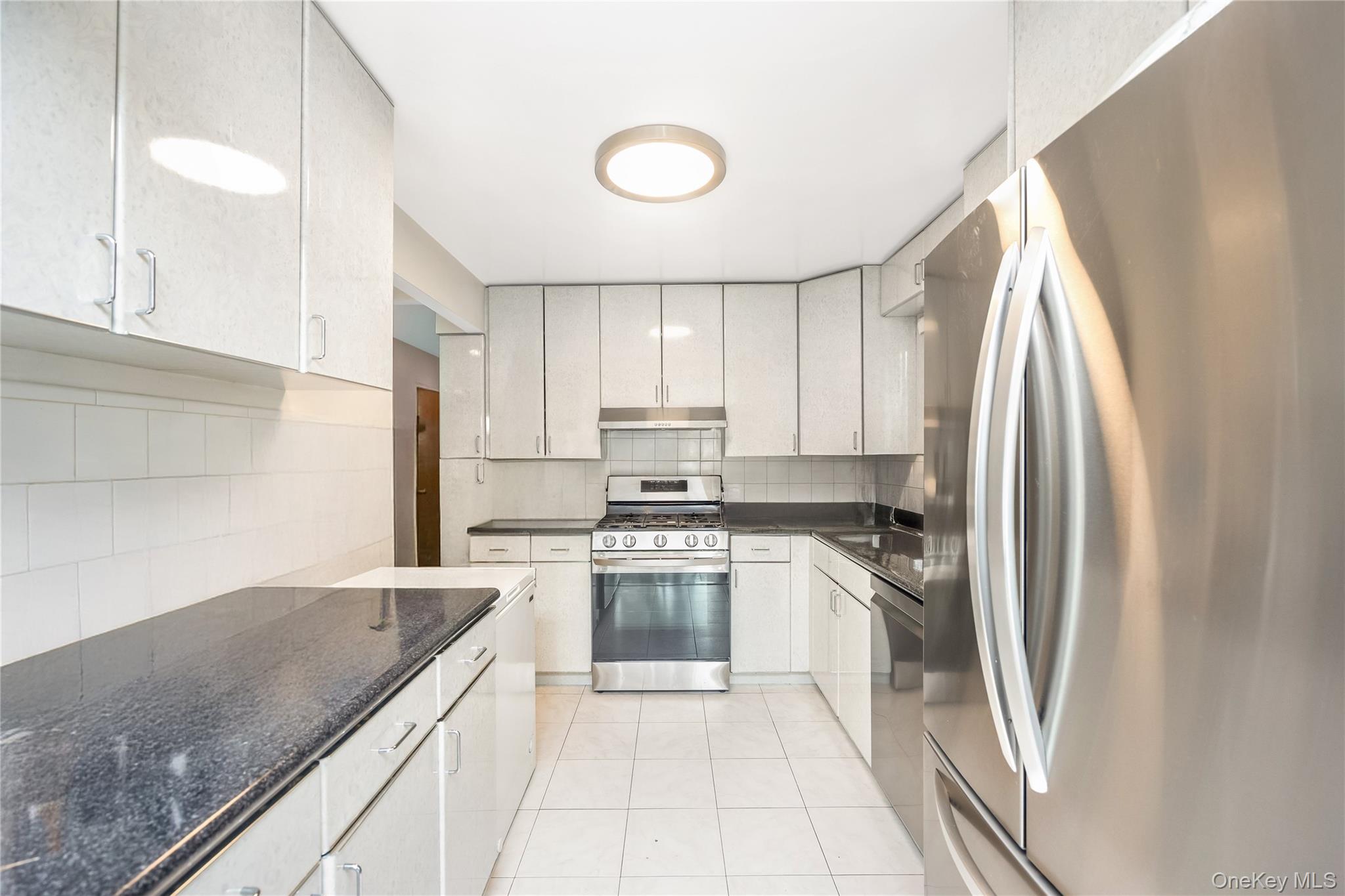 71-59 58th Road Queens, NY 11378 - Photo 15 of 34 a kitchen with stainless steel appliances granite countertop a refrigerator sink and stove
