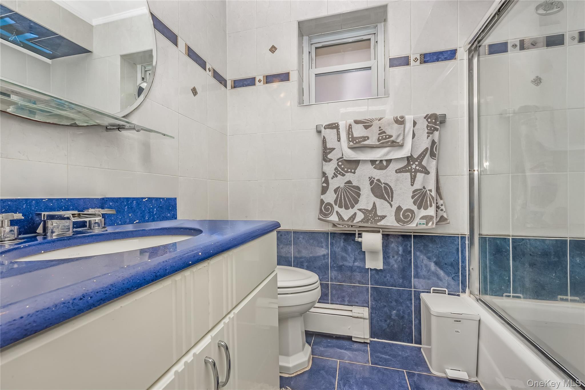 71-59 58th Road Queens, NY 11378 - Photo 18 of 34 a bathroom with a sink a toilet and shower curtain