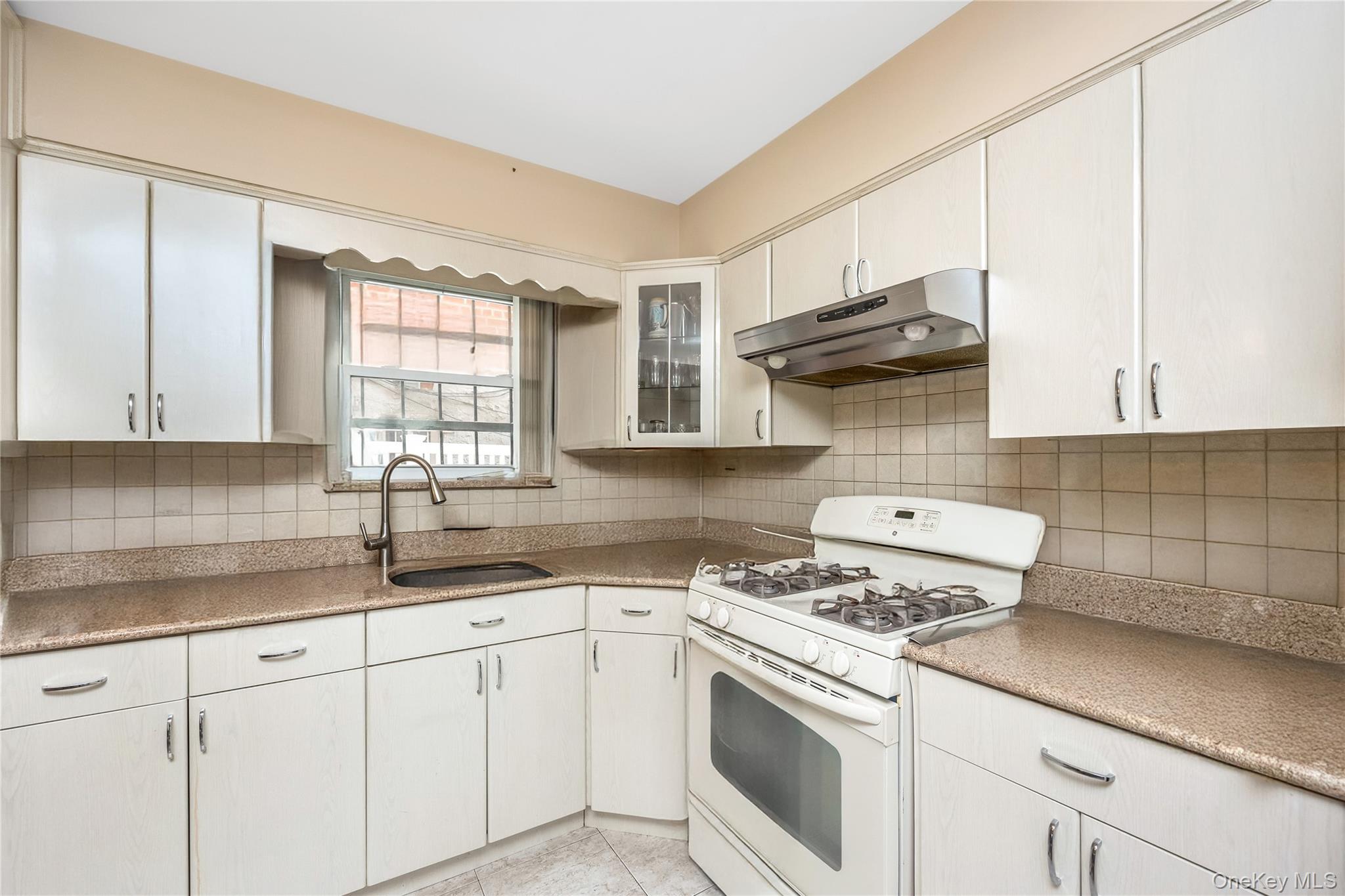 71-59 58th Road Queens, NY 11378 - Photo 4 of 34 a kitchen with granite countertop a sink stainless steel appliances and cabinets