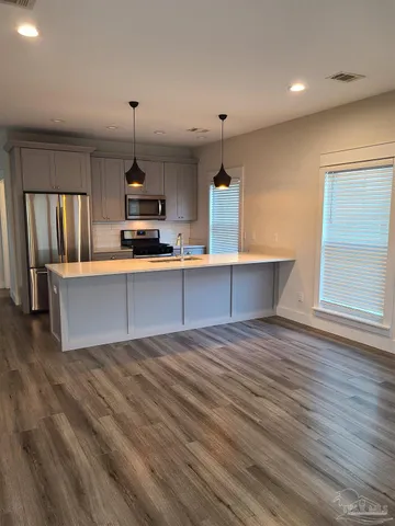 a kitchen with kitchen island a sink stove and wooden floor