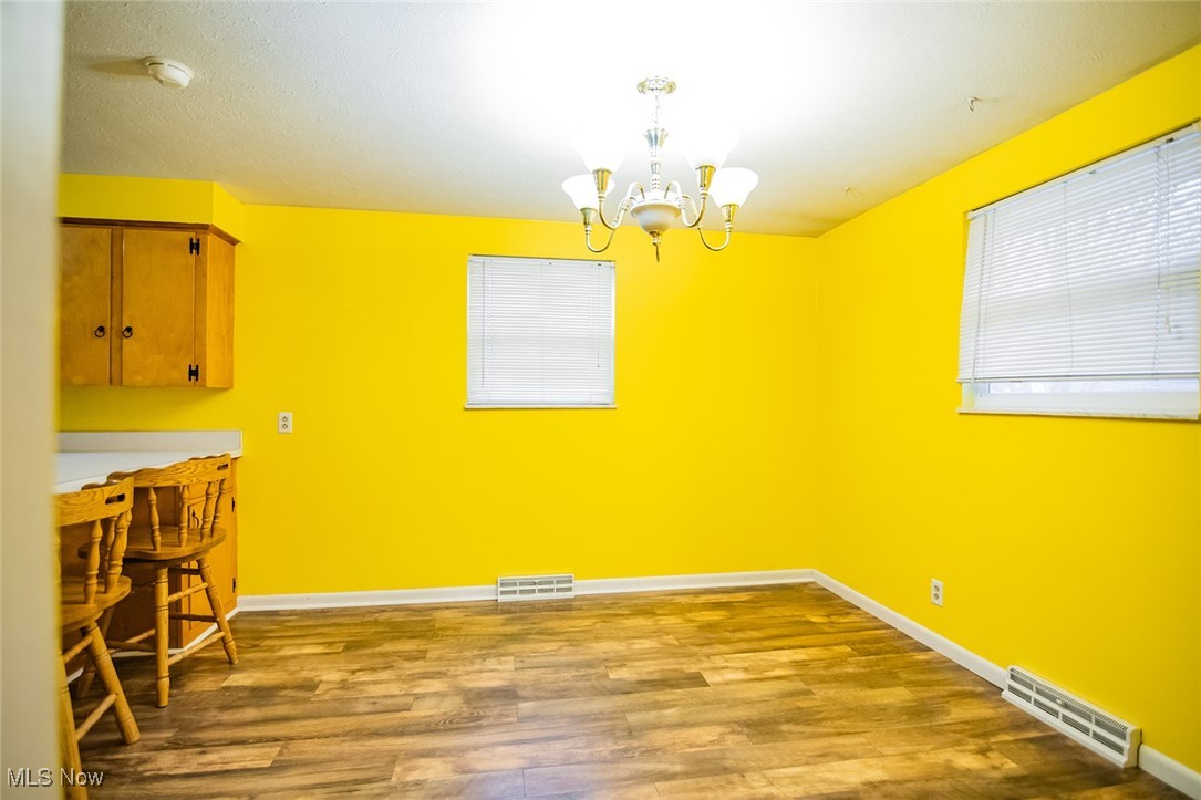 91 Mike Street Washington, WV 26181 - Photo 14 of 42 Unfurnished dining area with dark wood-style flooring and a chandelier