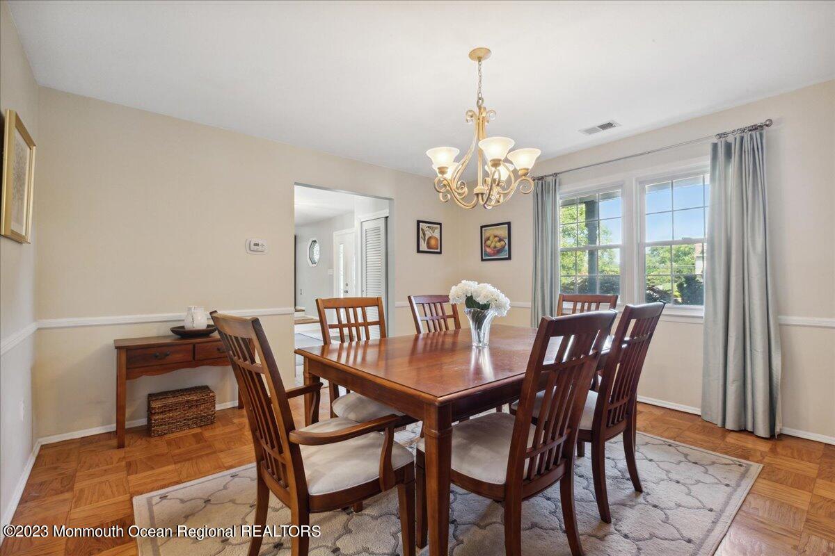 136 Lancaster Road Freehold, NJ 07728 - Photo 11 of 44 a view of a dining room with furniture a chandelier and wooden floor