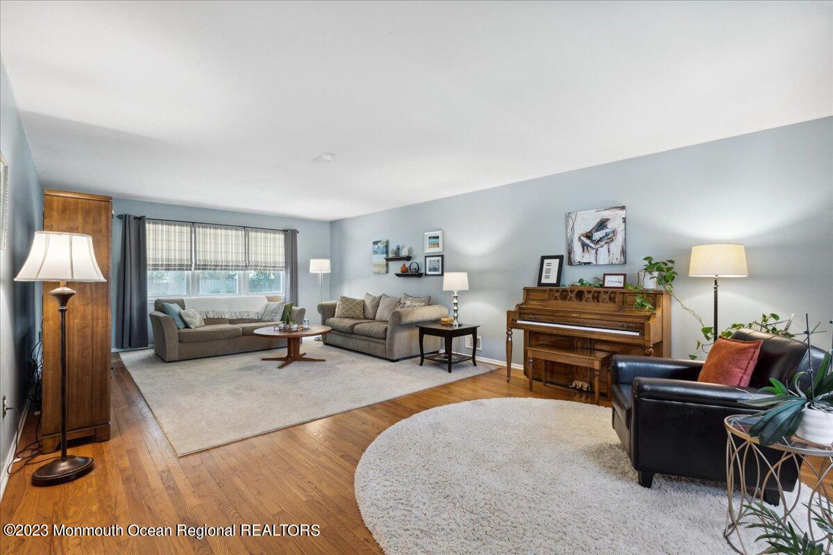 136 Lancaster Road Freehold, NJ 07728 - Photo 6 of 44 a living room with furniture a piano and a flat screen tv