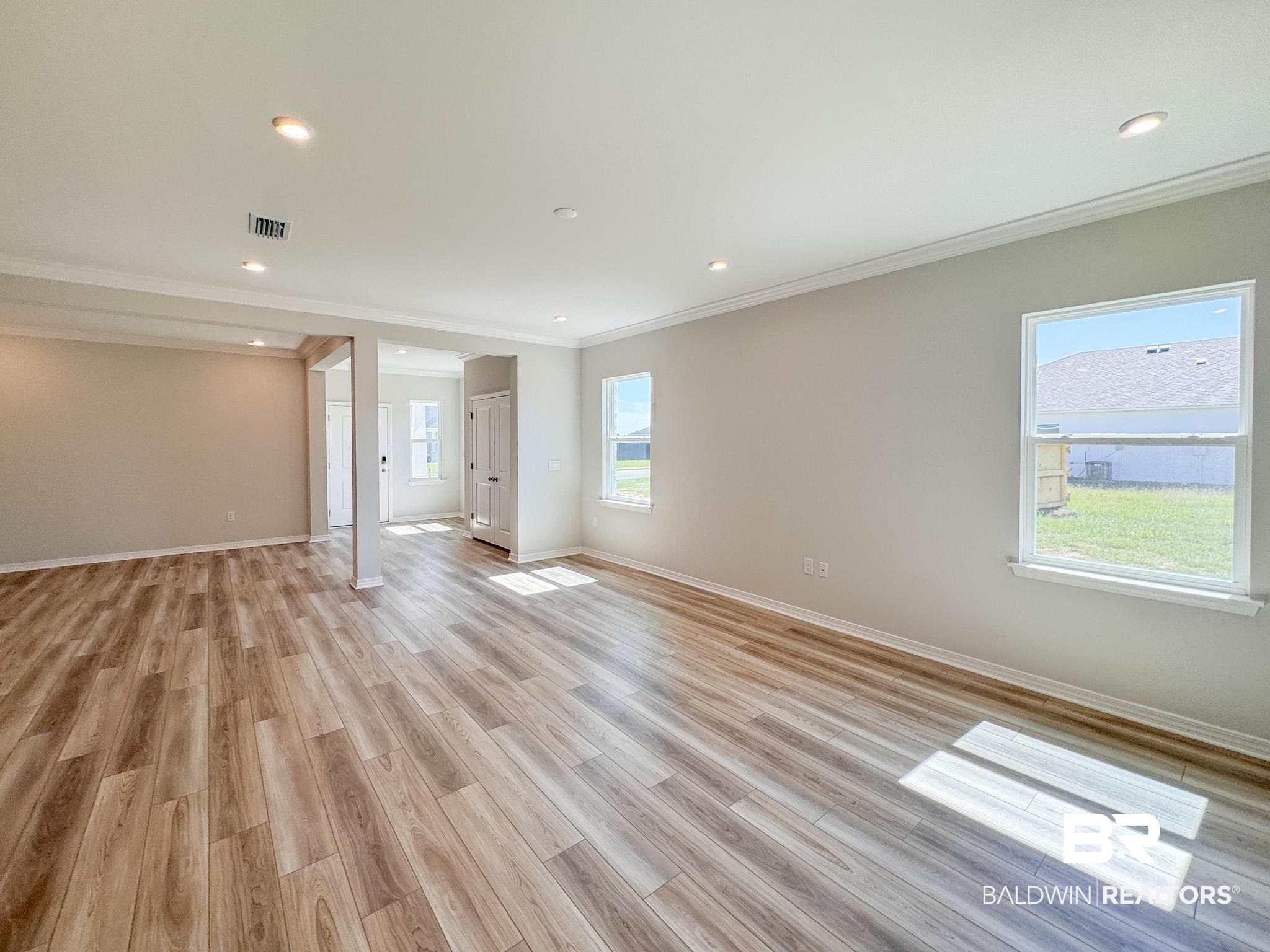 23939 Dominus Drive Daphne, AL 36526 - Photo 4 of 9 Empty room featuring crown molding, plenty of natural light, light wood-style flooring, and recessed lighting