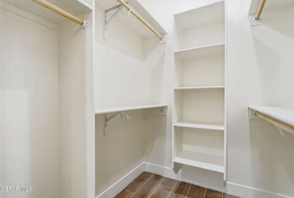 a view of walk in closet with empty racks