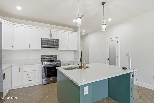 a kitchen that has a lot of cabinets in it and wooden floors