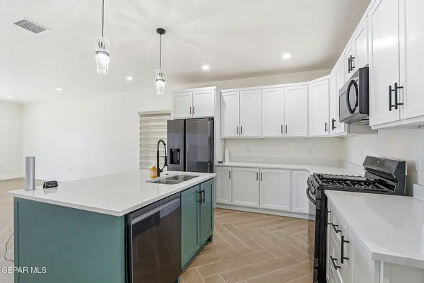 a kitchen that has a lot of cabinets in it and appliances