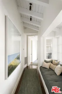 a living room with a bed and glass windows