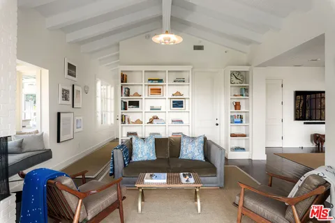 a living room with furniture a flat screen tv and kitchen view