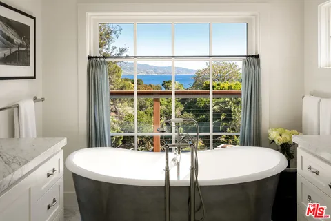 a bathroom with a granite countertop sink and a window