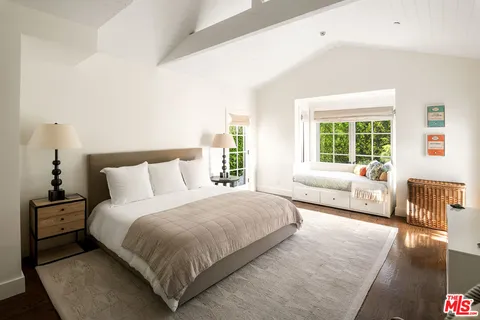 a bedroom with a bed and a couch with window