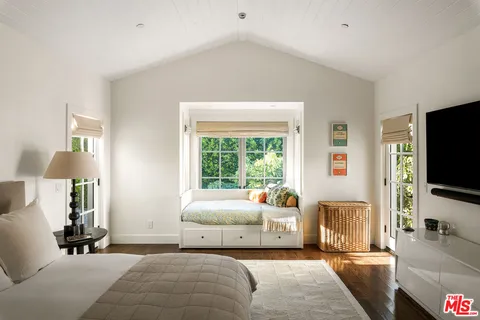 a bedroom with furniture and a flat screen tv