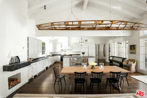a dining hall with stainless steel appliances a table and chairs
