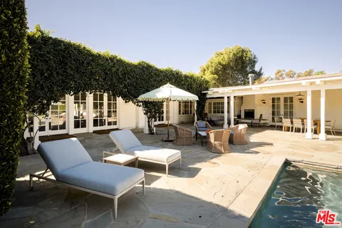 a backyard of a house with swimming pool and furniture