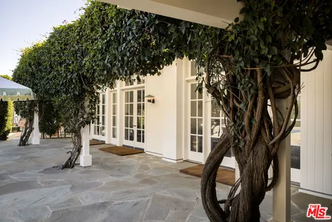 a front view of a house with a tree