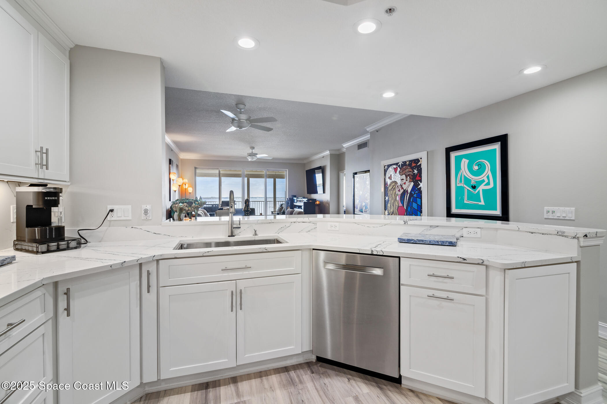 480 Sail Lane, Unit 703 Merritt Island, FL 32953 - Photo 8 of 41 a kitchen with white cabinets and sink