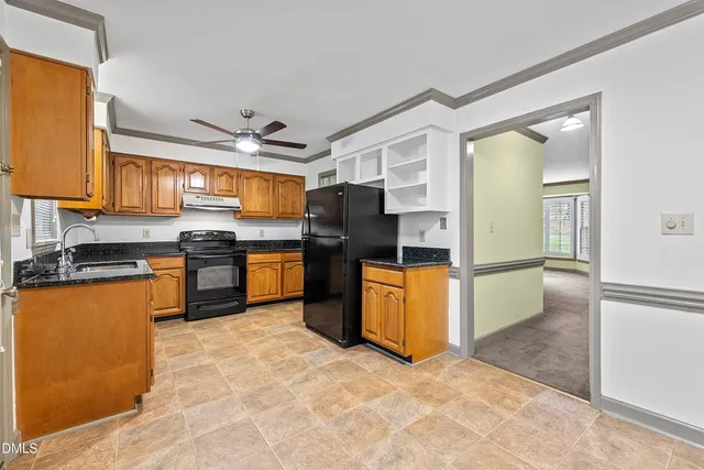 a kitchen with stainless steel appliances granite countertop a stove refrigerator and a sink