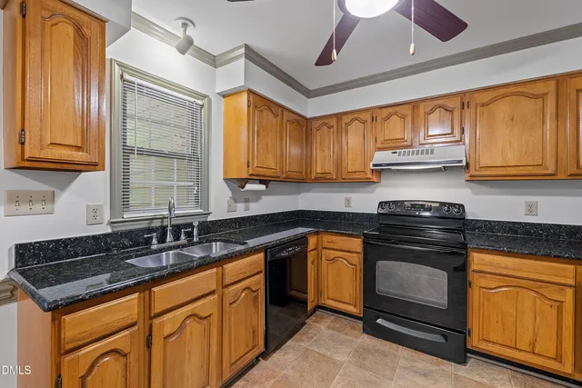 a kitchen with granite countertop cabinets stainless steel appliances a sink and a window