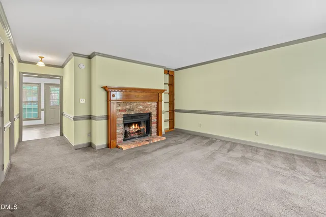 a view of an empty room with a fireplace and a window