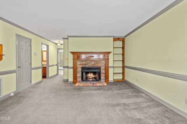 a view of an empty room with a fireplace and a window
