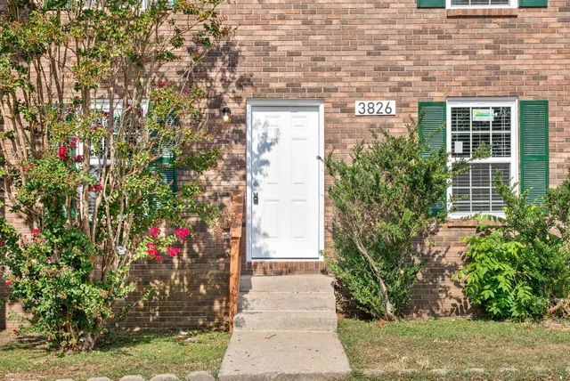 a front view of a house with a yard and flowers