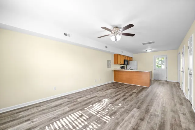 a view of a kitchen with wooden floor and a ceiling fan