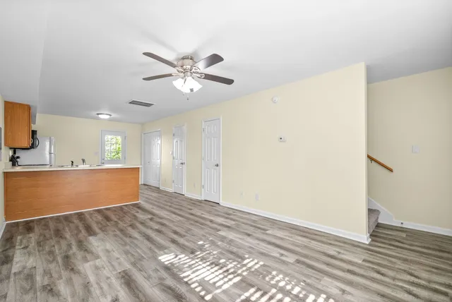 a view of room with wooden floor and ceiling fan