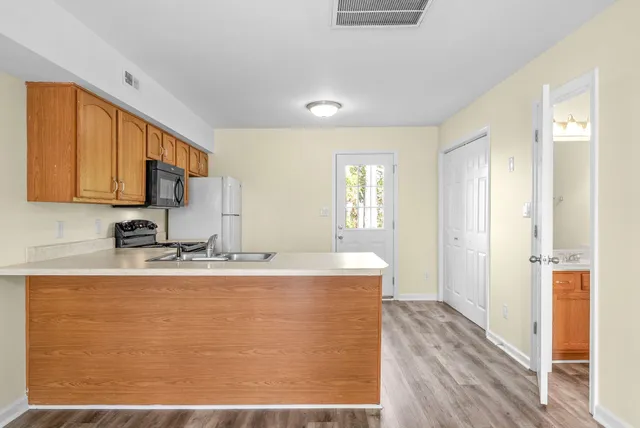 a kitchen with a sink a refrigerator and cabinets