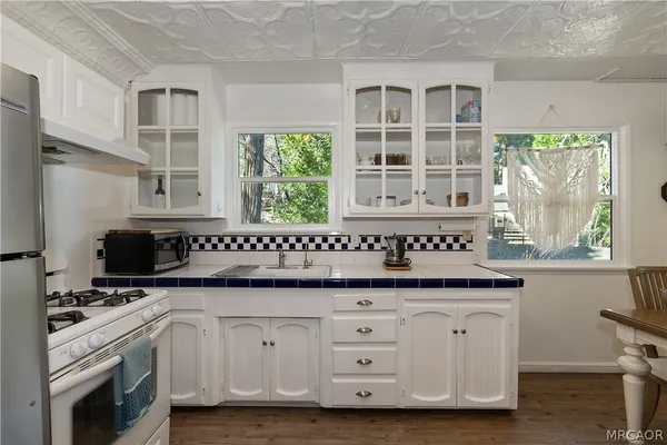 a kitchen with stainless steel appliances granite countertop a sink and a refrigerator