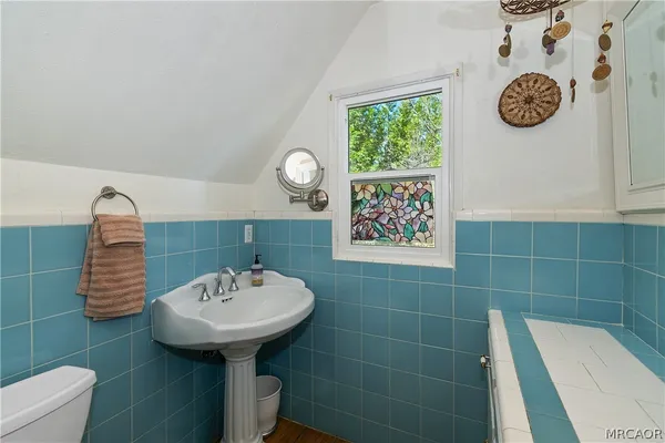 a bathroom with a sink a toilet and mirror