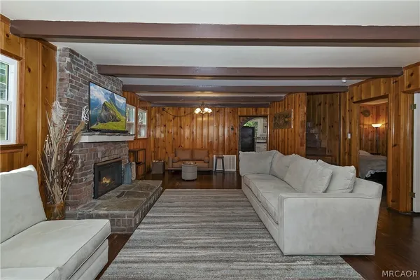 a living room with furniture a fireplace and a floor to ceiling window