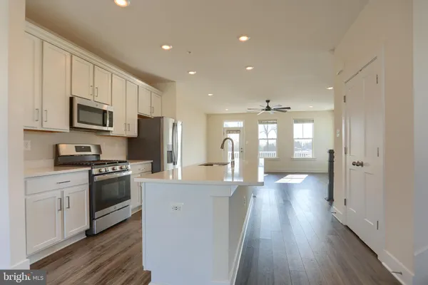 a kitchen with stainless steel appliances kitchen island granite countertop a stove a sink and a refrigerator