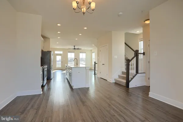 a view of a hallway with wooden floor table and chairs