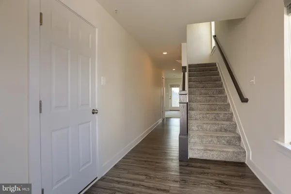a view of a hallway with wooden floor and entryway