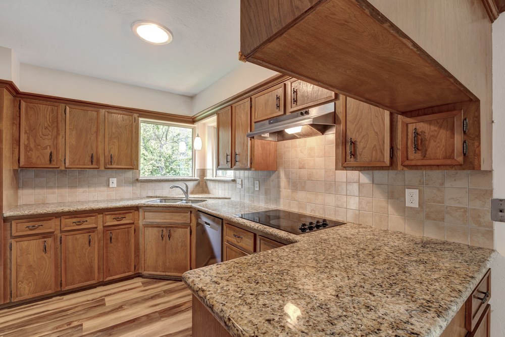 17 Wishbonebush Road Spring, TX 77380 - Photo 22 of 36 a kitchen with a sink a stove cabinets and wooden floor