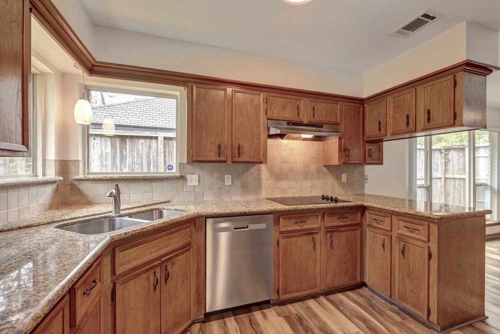 17 Wishbonebush Road Spring, TX 77380 - Photo 24 of 36 a kitchen with stainless steel appliances granite countertop white cabinets a sink and a window