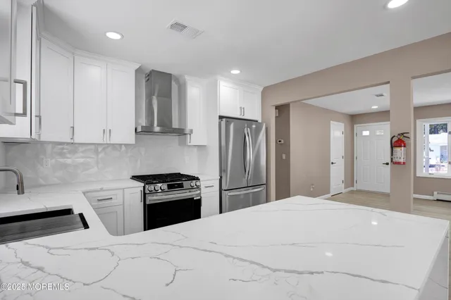 a kitchen with a refrigerator and a stove top oven