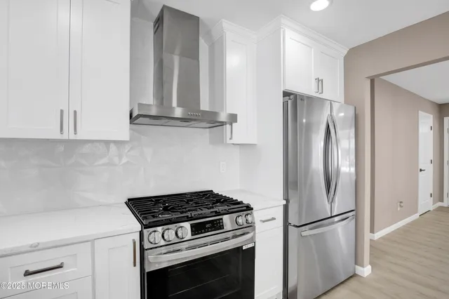 a kitchen with stainless steel appliances granite countertop a refrigerator stove and microwave