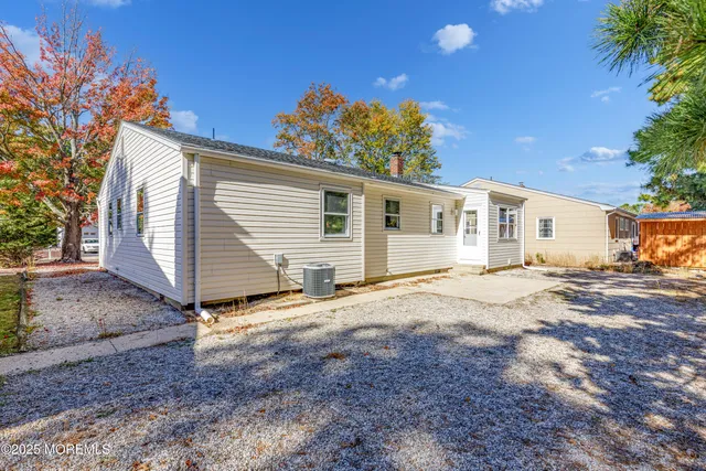 a view of a house with backyard and a tree