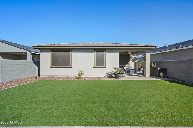 a view of a backyard with table and chairs and potted plants