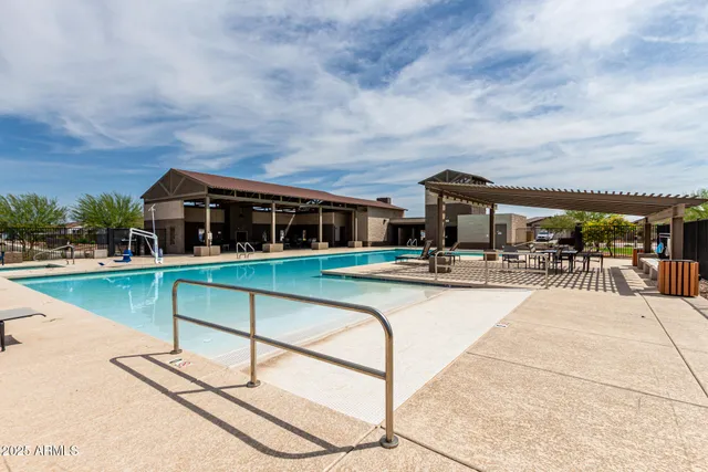 a view of house with swimming pool and seating