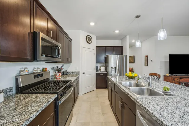 a kitchen with stainless steel appliances granite countertop a sink stove and refrigerator