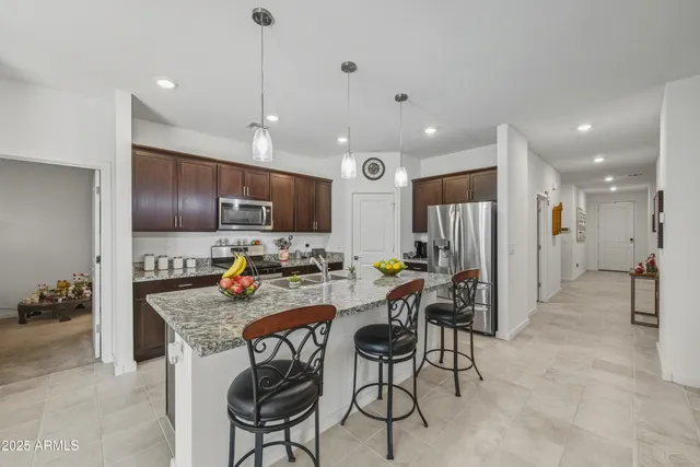 a kitchen with stainless steel appliances granite countertop a refrigerator and a stove top oven