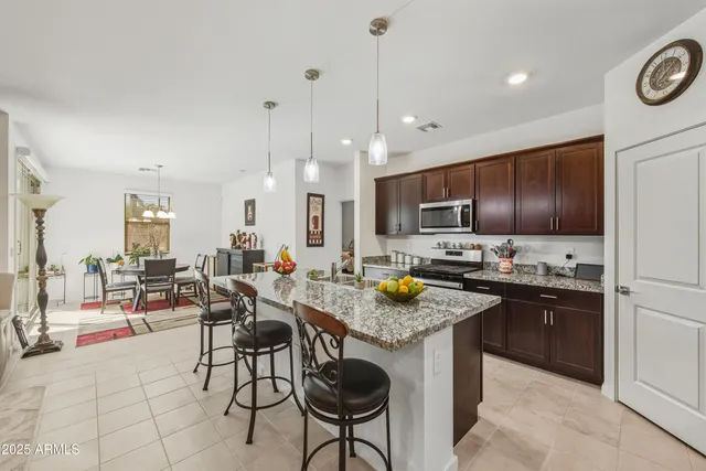 a kitchen with a stove a sink a oven a dining table and chairs