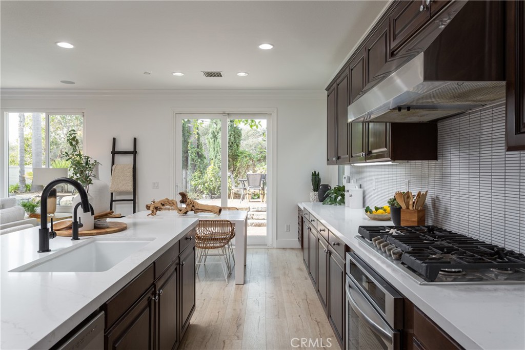 308 Via Los Tilos San Clemente, CA 92673 - Photo 12 of 43 a kitchen with kitchen island granite countertop a sink a stove cabinets counter space and stainless steel appliances