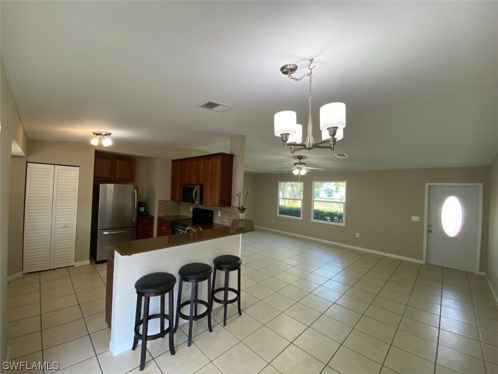 18258 Maple Road Fort Myers, FL 33967 - Photo 11 of 14 a kitchen with granite countertop a stove a refrigerator and a sink