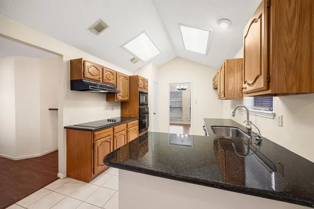 a kitchen with stainless steel appliances granite countertop a sink a microwave counter space and cabinets
