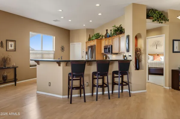 a dining hall with stainless steel appliances granite countertop a table and chairs